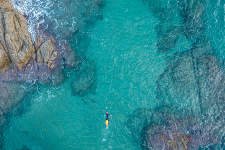 Aerial top view from drone of a swimmer in open water with wetsuit and buoyの写真素材