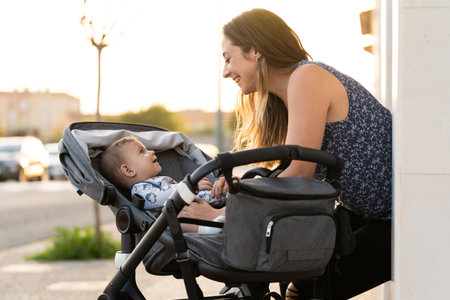 Mother and her son in the baby stroller at the door of their house