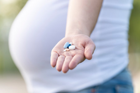 Pregnant woman showing some pills in her handの写真素材
