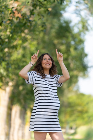 Photo with copy space to insert something with a pregnant woman pointing upの写真素材