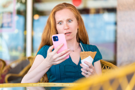 Woman surprised by something she is looking at with her smartphoneの写真素材
