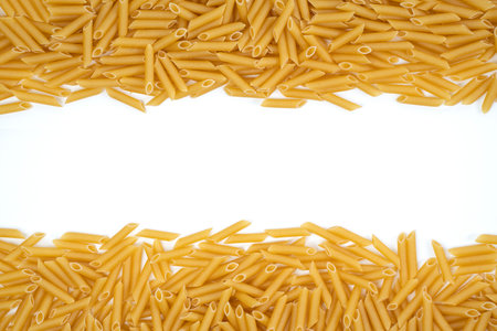 Pile of dried macaroni on top of a white background in studio with copy spaceの写真素材