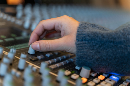 Macro shot of a hand in a control panel of a music recording studioの写真素材