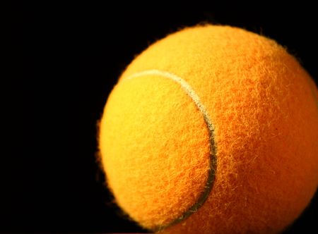 orange tennis ball on black backgroundの写真素材