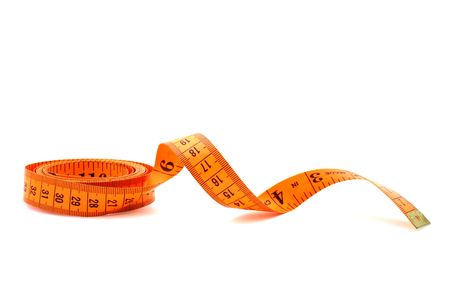 orange tape measure over a white surfaceの写真素材