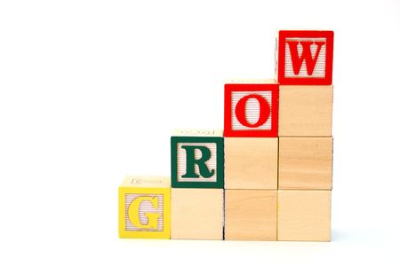word grow formed by alphabet wood blocks on a white surfaceの写真素材