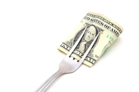 dollar bill wrapped in a fork over a white surfaceの写真素材