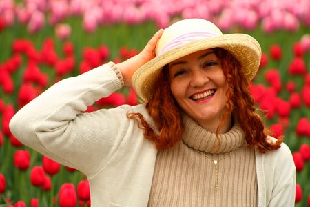 portrait of a beautiful young woman on a garden of tulipsの写真素材