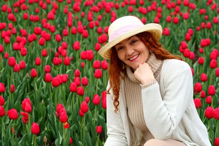 portrait of a beautiful young woman on a garden of tulipsの写真素材
