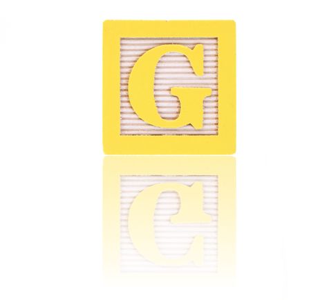 letter g in an alphabet wood block on a reflective surfaceの写真素材