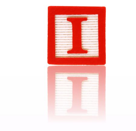 letter i in an alphabet wood block on a reflective surfaceの写真素材