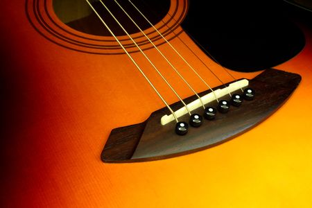 detail view of the bridge and strings of an acoustic guitar