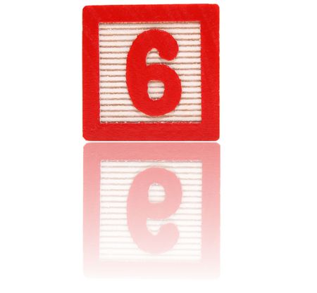 number six in an alphabet wood block on a reflective surfaceの写真素材