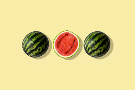 Three halves of watermelon, isolated and against yellow summer backgroundの写真素材