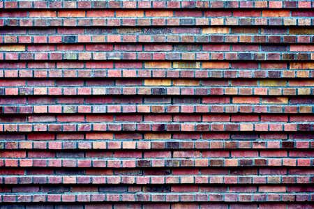 Vintage brick wall; multi-colored red bricks, textured background; urban surfaceの写真素材