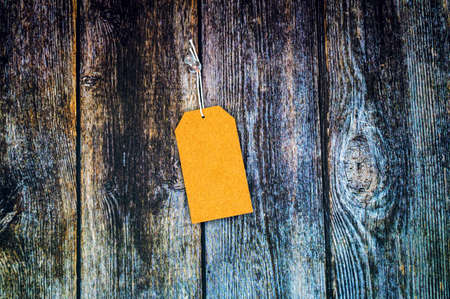 Blank gift label mockup with copy space pinned on a vintage wooden background.の写真素材