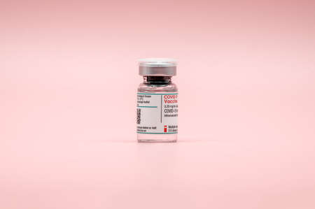 COVID-19 vaccine. Glass vial against pink background. mRNA vaccine against the coronavirus (SARS-CoV-2).のeditorial素材