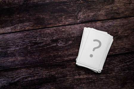 Chance cards, gambling, FAQ or unanswered questions Concept. A stack of playing cards, printed with a question mark, on a rustic wooden background. Table top view, flat lay, copy space.の写真素材