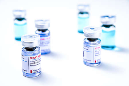 Coronavirus vaccine, COVID-19 vaccine, corona vaccination. Different vials of mRNA vaccine for injection on white background.のeditorial素材