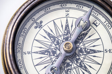 Strategic direction, business success, orientation or navigation concept. Close up of a vintage brass compass with compass needle and wind rose.の写真素材
