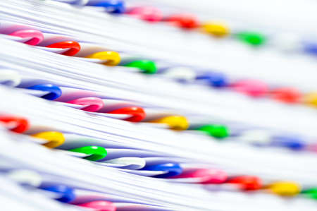Office work, bureaucracy or red tape concept. Colorful paperclips in a stack of files and papers.の写真素材