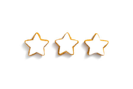 Three cinnamon stars with sugar glaze against white background. Tasty Christmas pastry triple.の写真素材