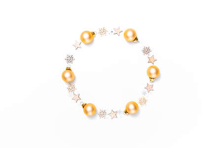 Wreath of golden Christmas baubles, wooden stars and snowflakes against white background. Christmas, winter or new year's arrangement. Flat lay, top view, copy space.の写真素材