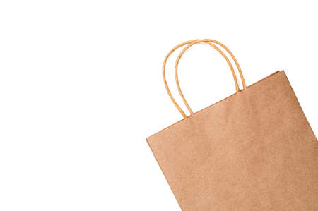 Kraft paper gift or shopping bag against white background. Top view, flat lay, copy space.の写真素材