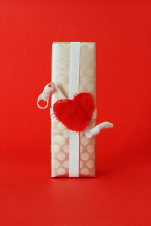 A gift box wrapped in golden paper on a red ground