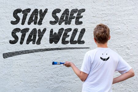Boy in front of the text STAY SAFE and WELLの写真素材