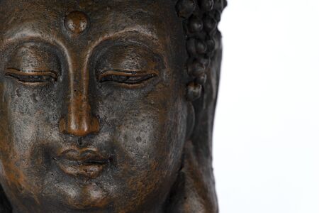 Head of an old Buddha statue isolated on white backgroundの写真素材