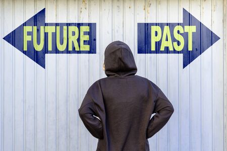 A female model in front of two blue guideposts with yellow text FUTURE and PASTの写真素材