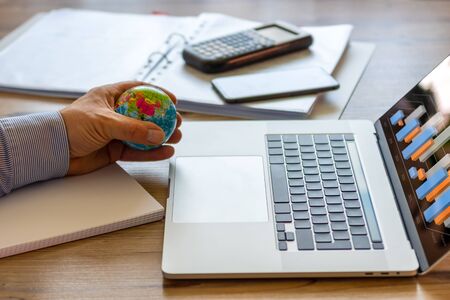 A businessman plays with a stress ball while he investigates the marketの写真素材