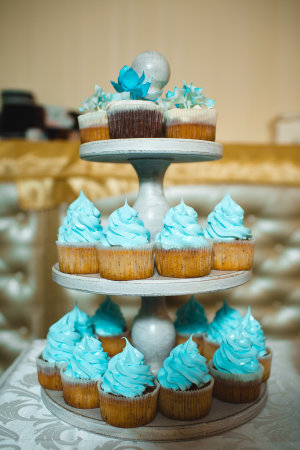 Cupcakes with blue buttercream frosting on a cake standの写真素材