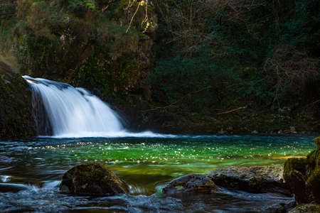 A river ends in a small waterfall where is a beautiful lakeの写真素材