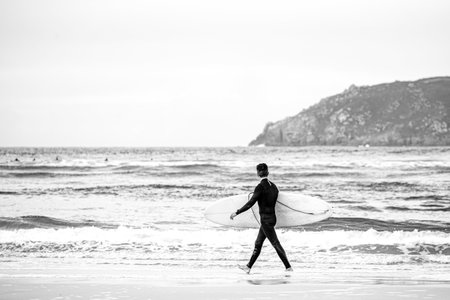 A surfer comes out of the water after a good surf sessionの写真素材