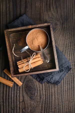 Healthy food condiment with medicinal properties, true Ceylon Cinnamon sticks and powder in a jar on wooden backgroundの写真素材