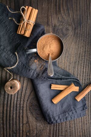 Healthy food condiment with medicinal properties, true Ceylon Cinnamon sticks and powder in a jar on wooden backgroundの写真素材