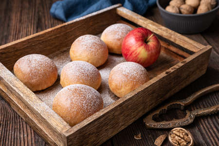Delicious sweet pastry, baked buns with apple and walnut filling, sprinkled with powdered sugarの写真素材