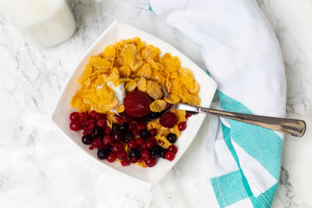 cereal bowl with berries, milk and yogurt on white background