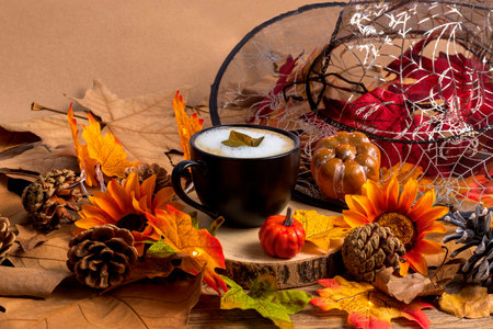Cup of coffee with witch hat, leaves and pumpkins, autumn and halloween backgroundの写真素材
