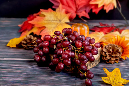 Bunch of red grapes on wood with autumn backgroundの写真素材