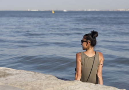 Young woman sitting on the beachの写真素材