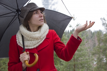 Young woman in red jacket with umbrellaの写真素材