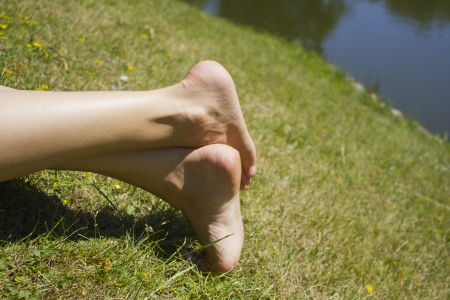 Legs on the grass by the waterの写真素材