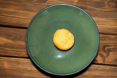 A small, golden-brown pound cake served on a vibrant green plate. Simple, delicious, and perfect for...