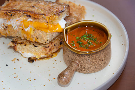 A warm and savory panini made with sourdough bread, fluffy scrambled egg, and a fresh tomato...