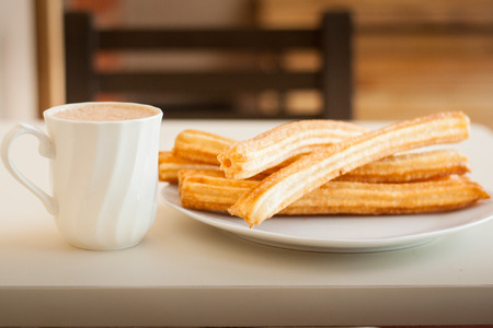 Several churros on small plate and milk with chocolateの写真素材