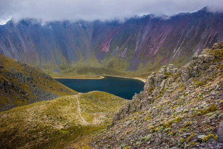 Hiking at an Amazing mountain lake  with fog, rocks and grass