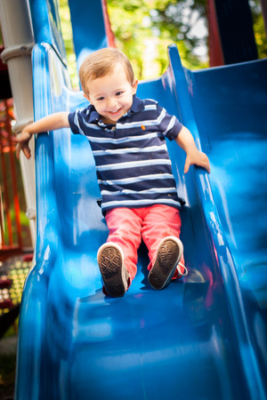 Happy smiling kid playing in the park playgroundの写真素材